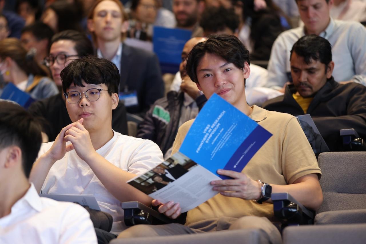 symposium attendees in the packed auditorium