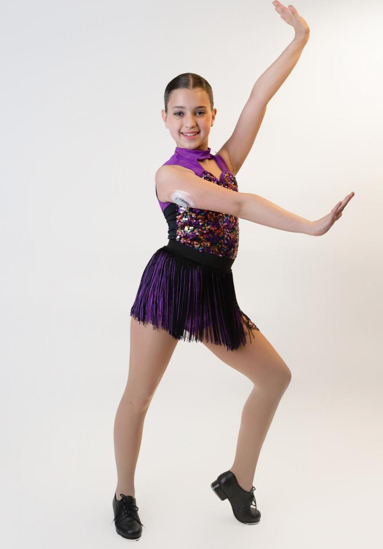 young dancer poses with glucose-monitoring sensor on her arm