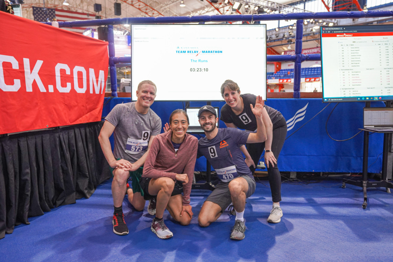 two men and two women posing in front of an indoor track