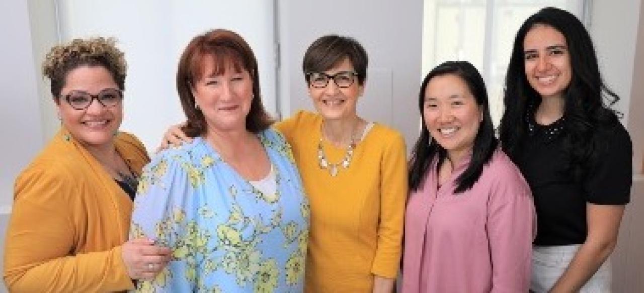 five women standing next to each other and smiling at the camera