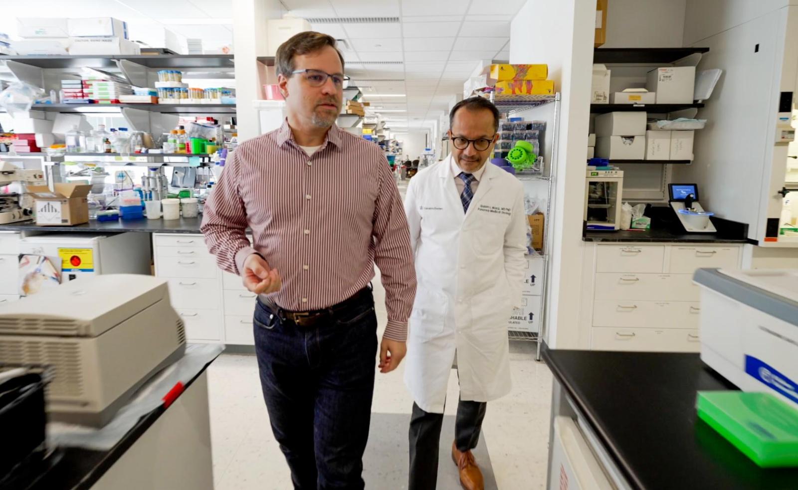 two researchers walking through a scientific laboratory