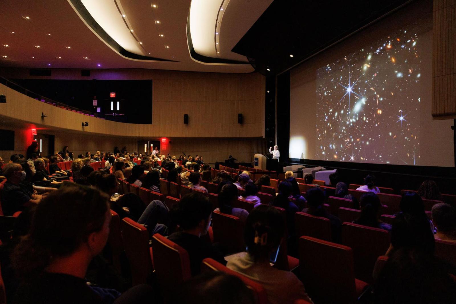 crowd in theater listening to Provost Olinto