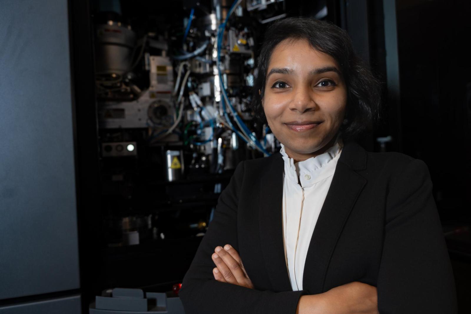 Columbia professor Akanksha Thawani standing in front of electron microscope
