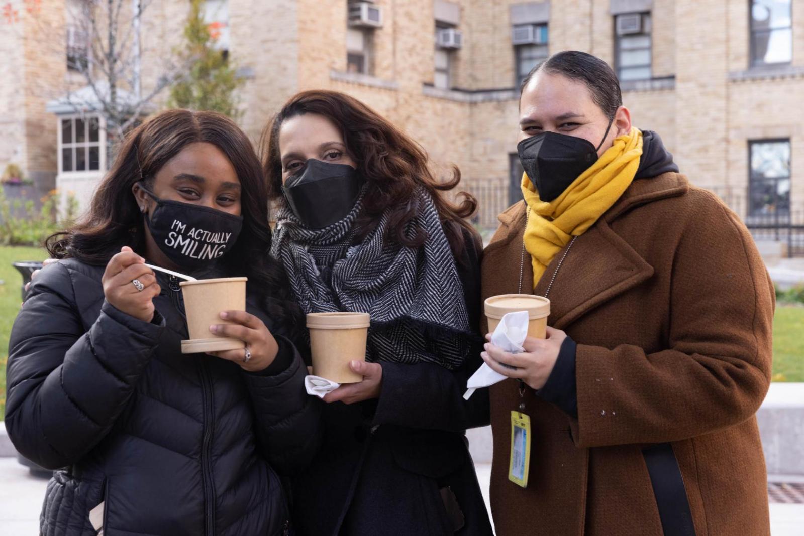 smiling people with hot soup at autumn festival