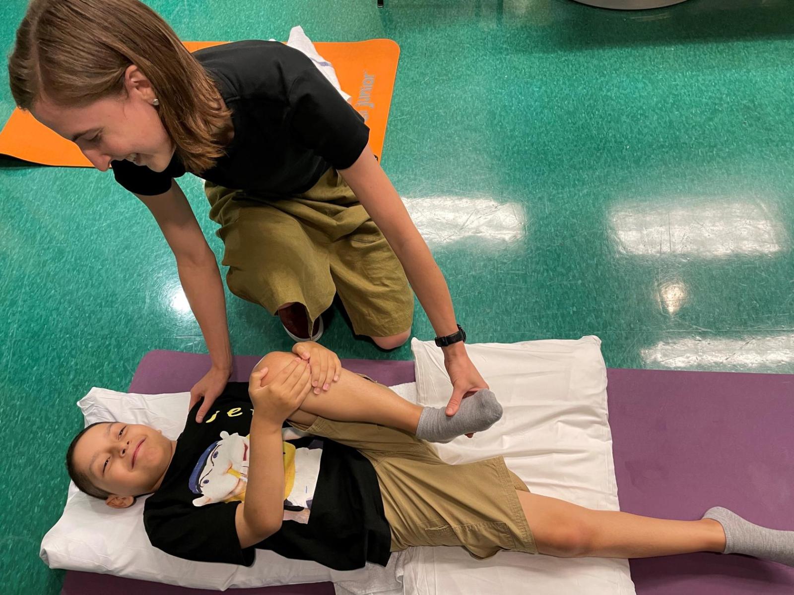 woman helping a child stretch his leg