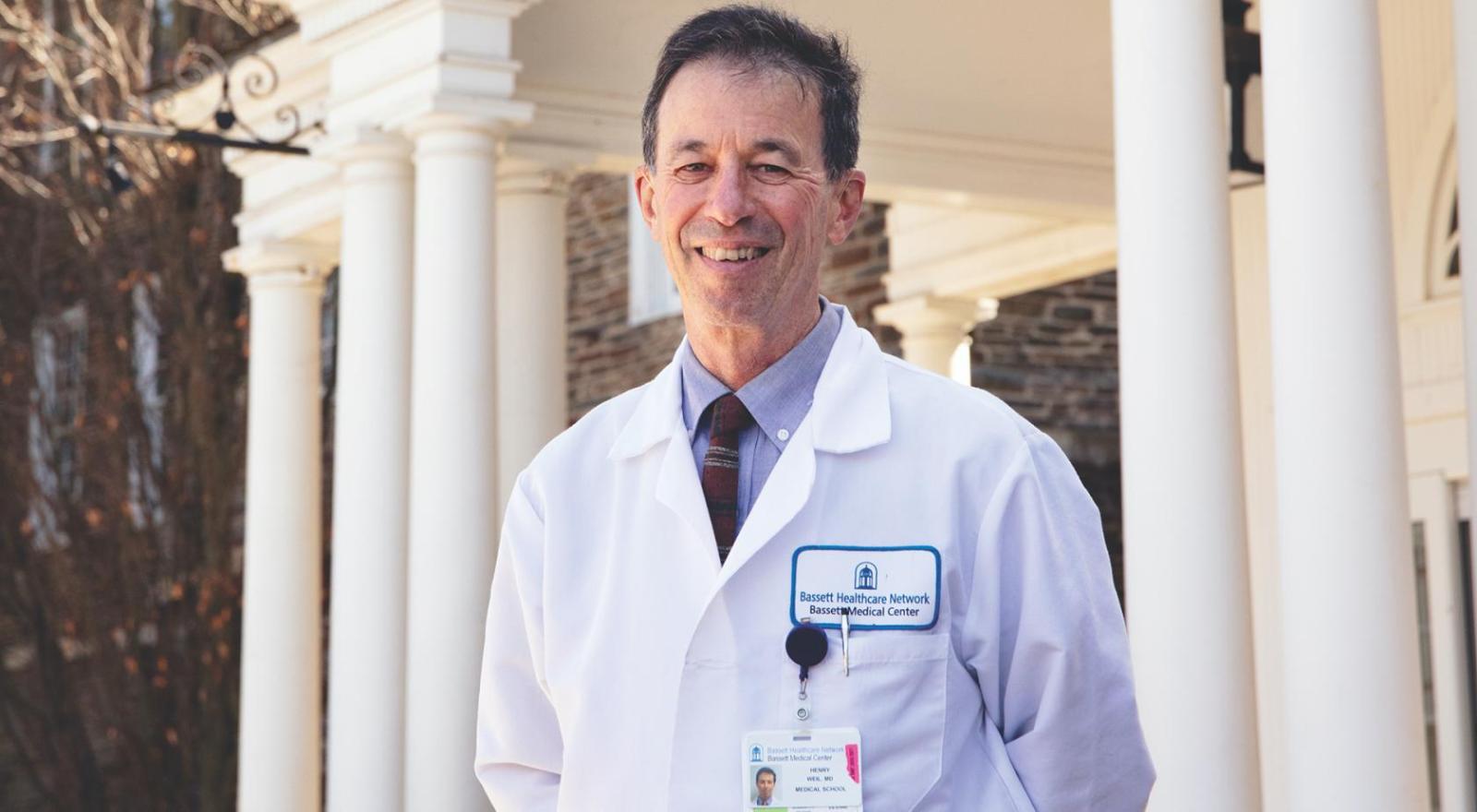 portrait of physician Henry Weil in front of a medical building