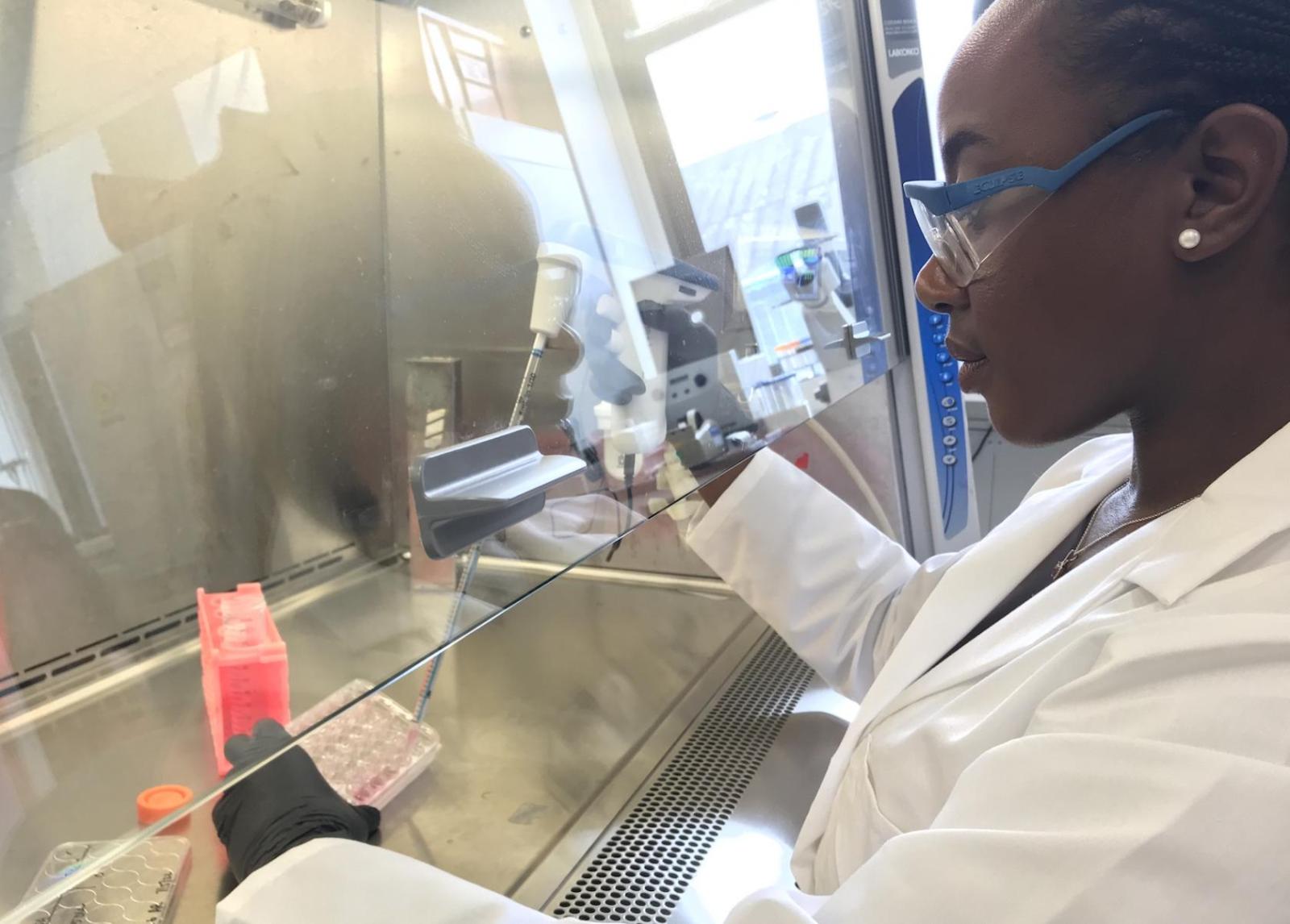 person pipetting liquids in a science laboratory