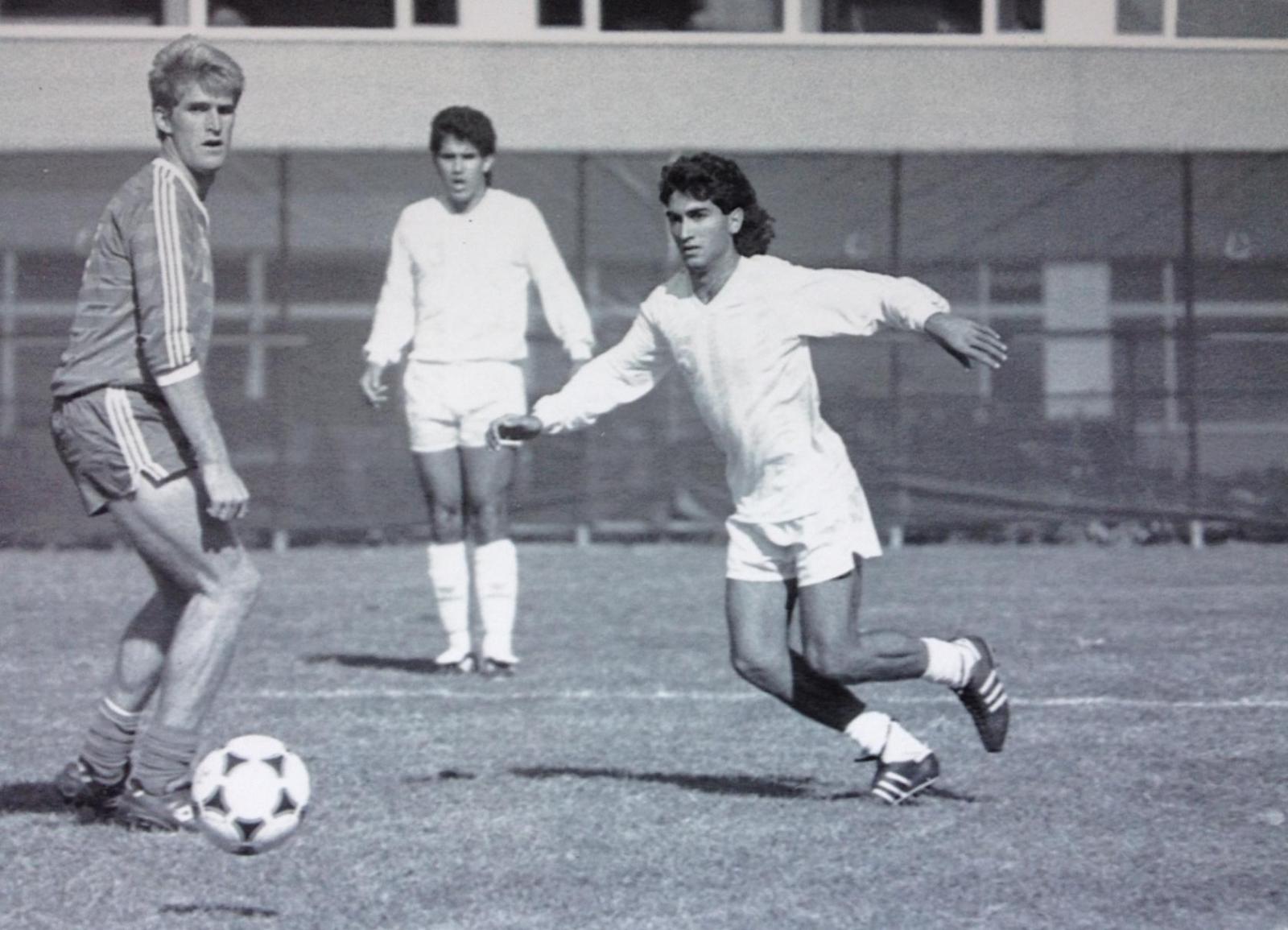 three men, including Christopher Ahmad, MD, playing soccer