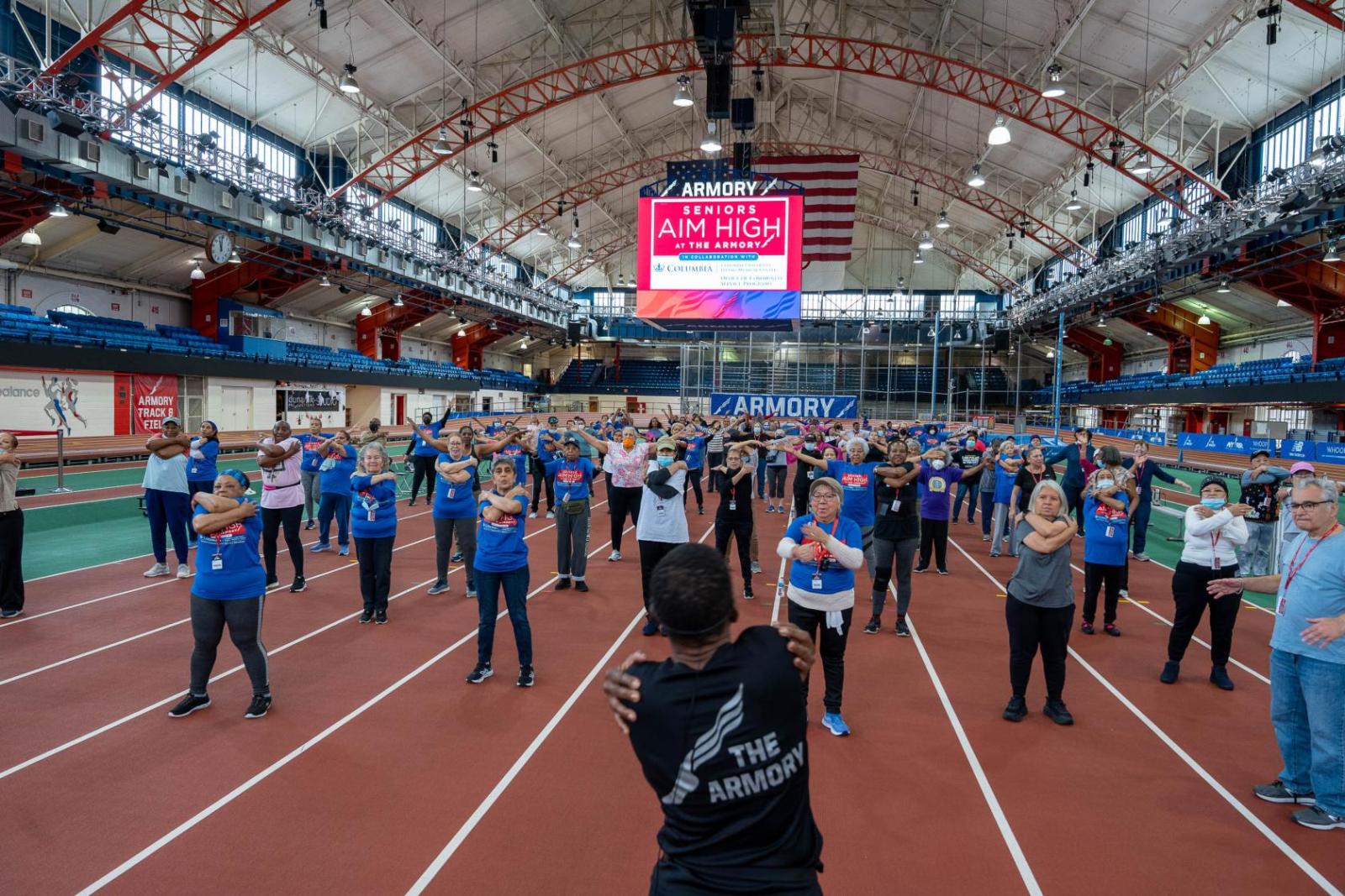 Fitness coach guides participants through group stretches after their workout