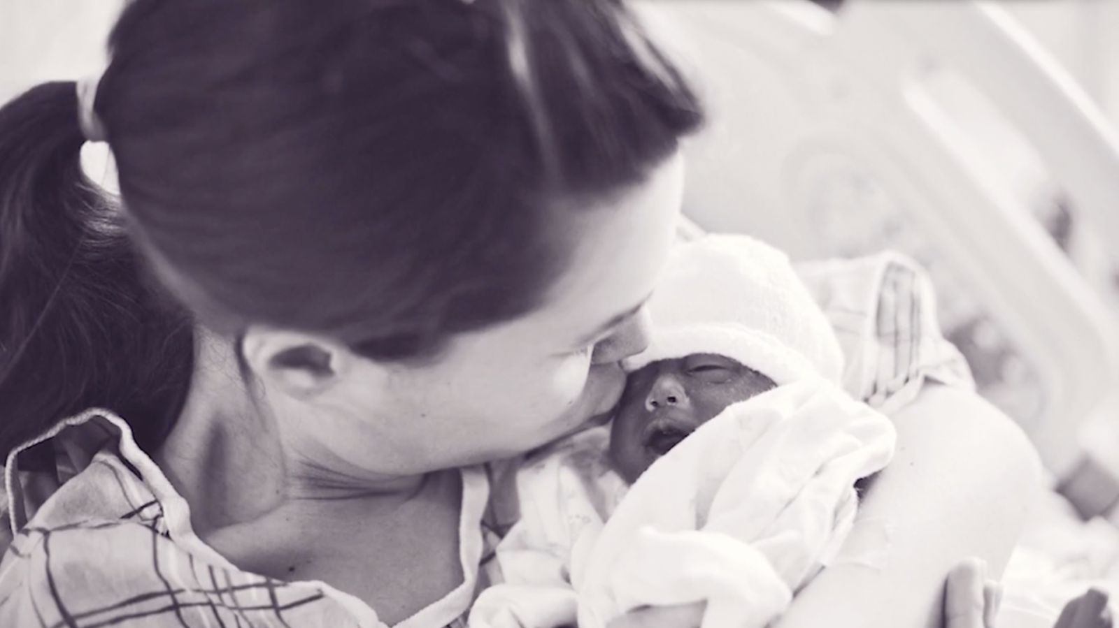 newborn cradled in mother's arms