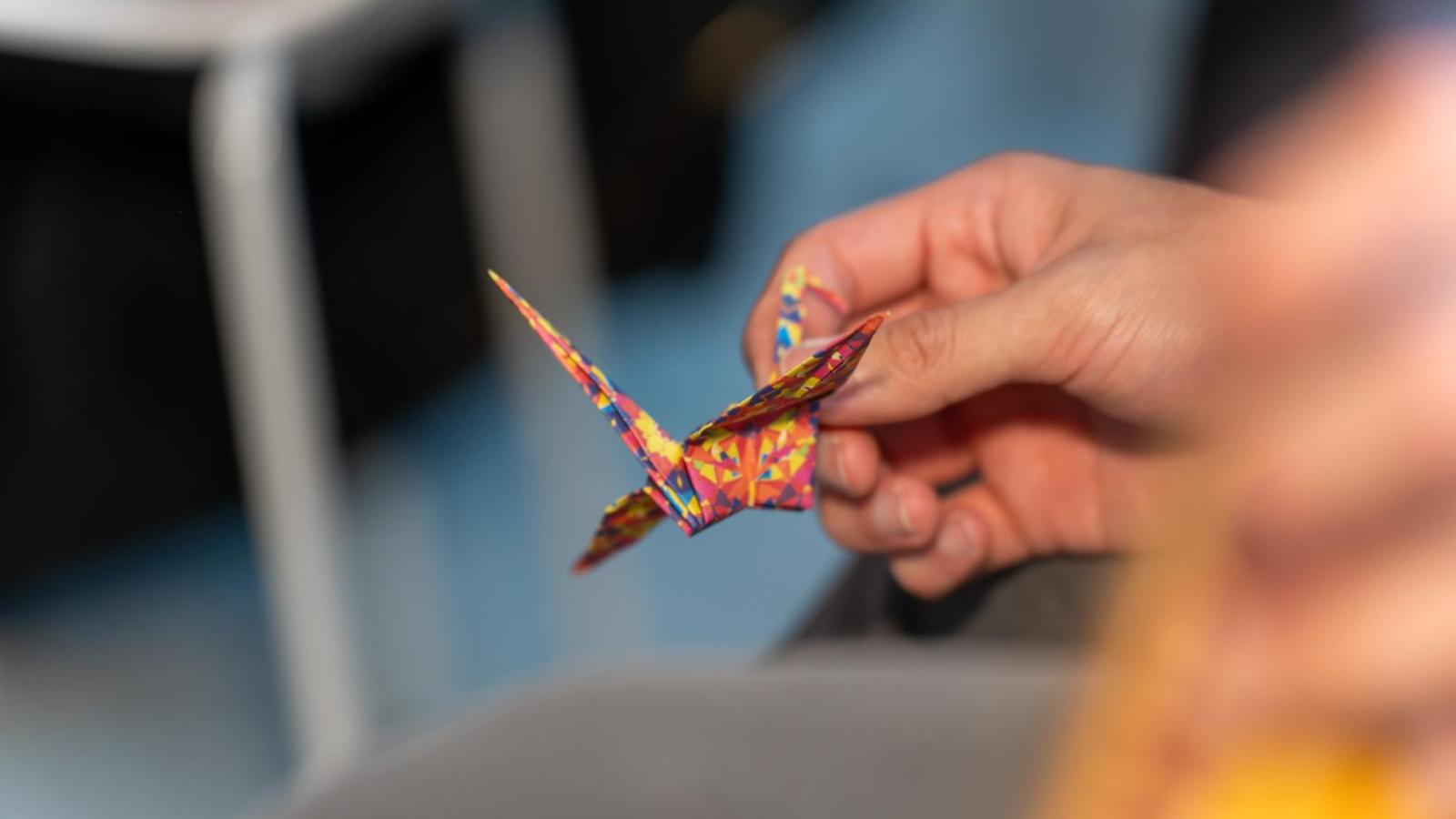 close-up of a hand holding a paper crane