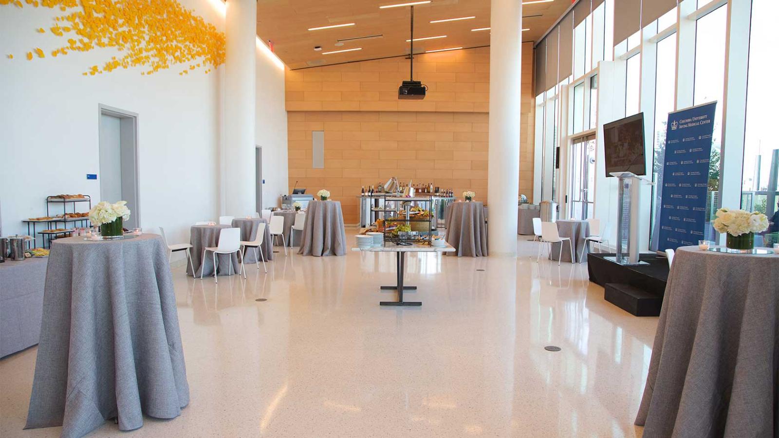A spacious reception hall set up with cocktail tables and catering stations.