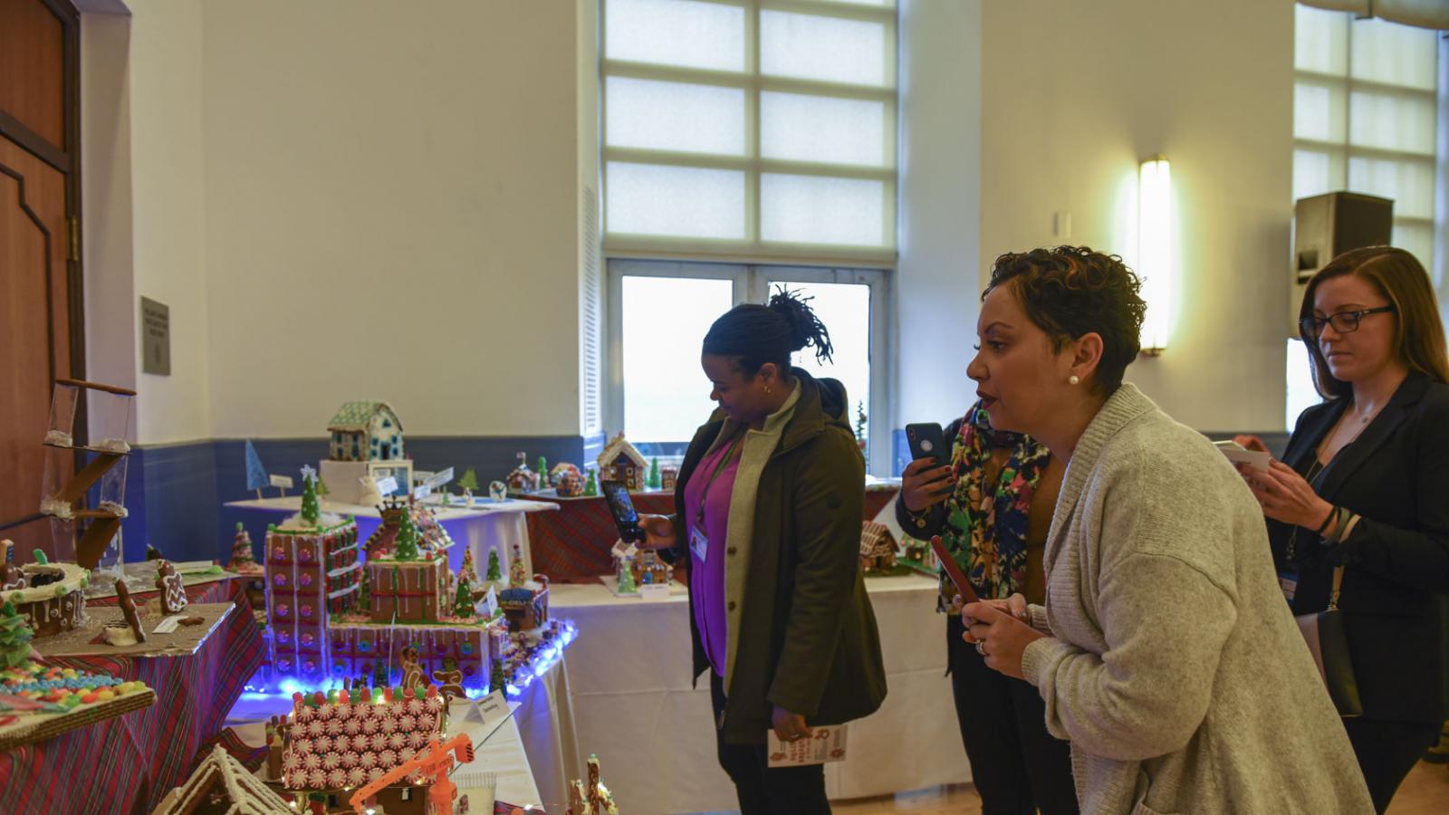 Columbia employees admire the gingerbread houses built by colleagues for the CUIMC Holiday Breakfast.