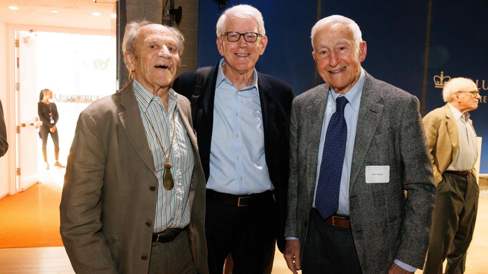 Three men stand together for a group photo
