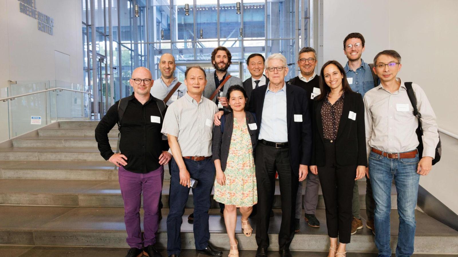 A group of people stand on a staircase together and pose for a group photo