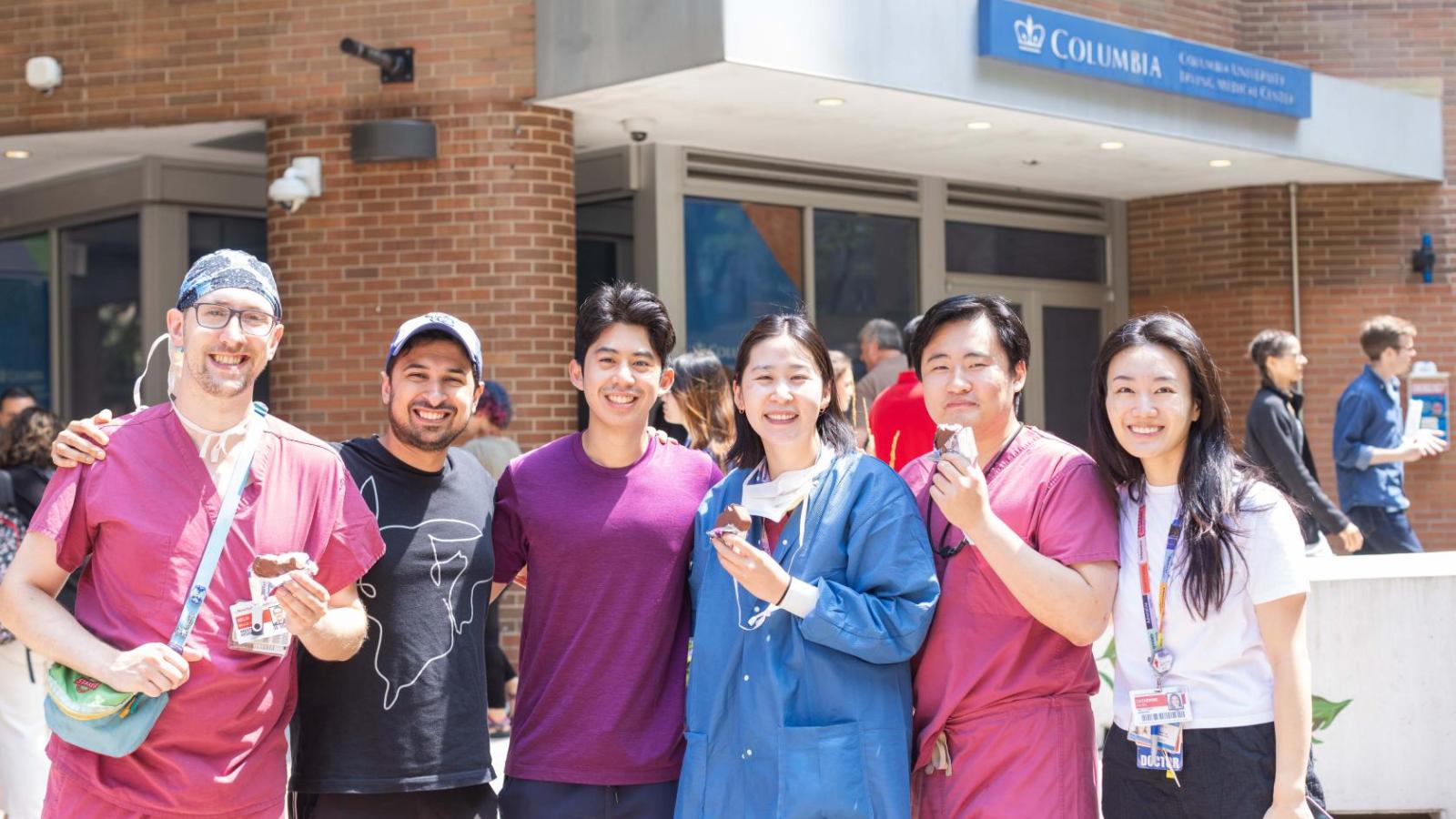 A group of people pose together with ice cream in their hands