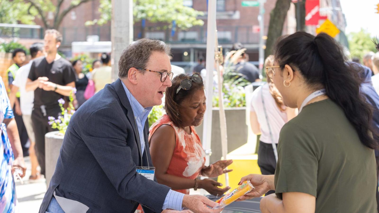 A man and woman hand out ice cream from a freezer