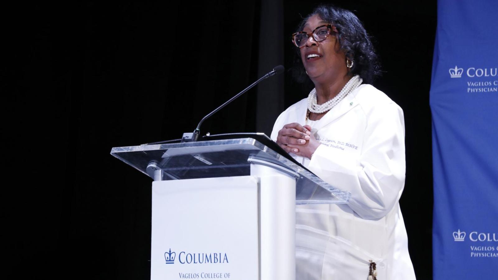 Dr. Monica Lypson speaking at a podium