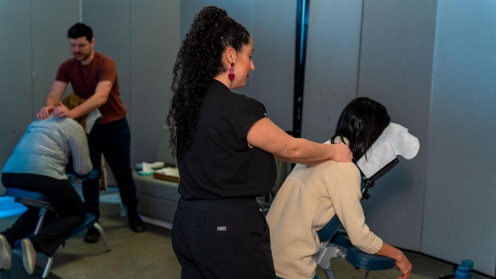 people on massage chairs having their necks massaged