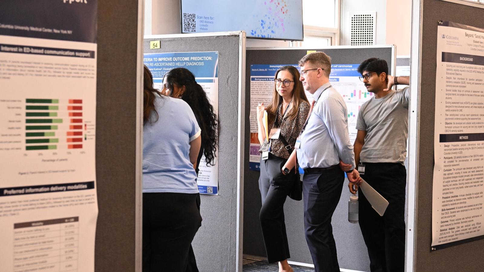 two judges review a student's research poster
