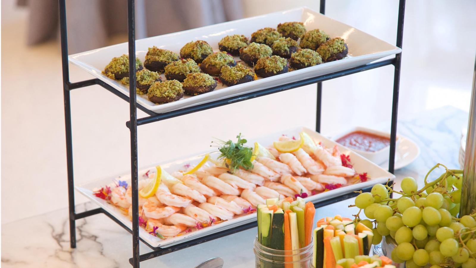 A station featuring shrimp cocktail and prosciutto-stuffed mushrooms