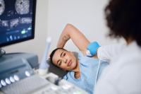 ultrasound probe applied to breast during an exam to look for breast cancer