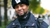 Uniformed public safety officer standing outdoors and smiling