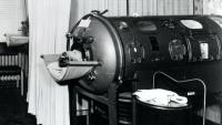 1950s photo of child with polio inside an iron cylinder