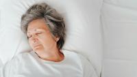 older adult sleeping in bed