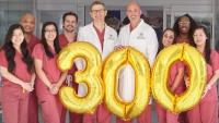 health care providers in scrubs holding balloons that spell 300