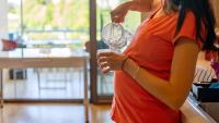 pregnant woman holding a glass of water