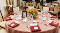 A table with place settings and menus tucked in napkins