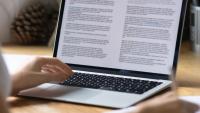 a person reading a scientific paper on a laptop