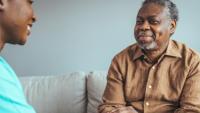 an older Black patient speaks with a health care provider