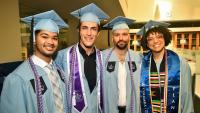 four nursing graduates wearing academic regalia at their graduation