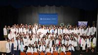 group photo of 140 Columbia DNP students wearing white coats