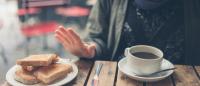 woman at café rejecting a plate of toast / Getty Images
