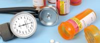 A stethoscope and blood pressure meter next to medication