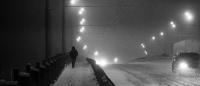 man walking at night on a snowy street