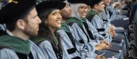Columbia medical students wearing blue robes and green hoods at their graduation