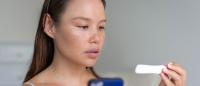 A woman waiting for pregnancy test results, holding her phone.