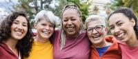 Happy multi generational women having fun together - Multiracial friends smiling on camera after sport workout outdoor - Main focus on african female face