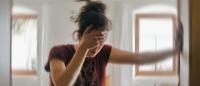 woman holding hand to her head and feeling dizzy