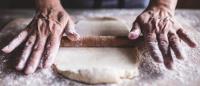 Hands rolling dough