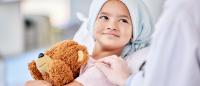 Shot of a little girl laying in bed at a hospital hugging teddy bear
