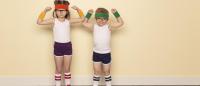 2 children in 80's sweatbands and workout gear flexing muscles ready to exercise