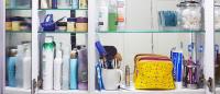 Bathroom medicine cabinet full of hair products, cosmetics, toiletries, creams, lotions, and more