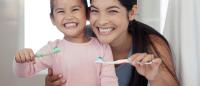 Portrait of mom and kid brushing teeth, dental healthy and cleaning in bathroom at home. Smiling aunt and child learning oral healthcare, wellness and heath