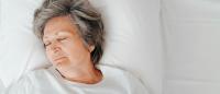 older adult sleeping in bed