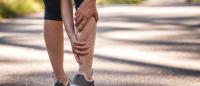 person holding sore calf muscle